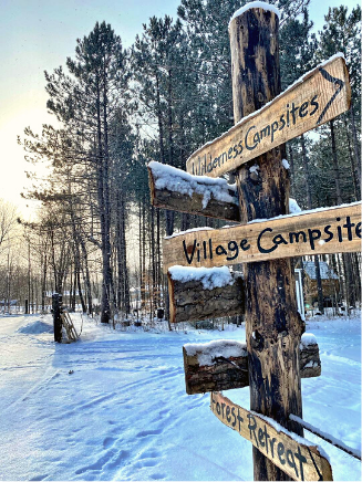 wooden direction signs on a snowy trail